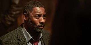 Idris Elba looks up at someone with a scowl in Luther