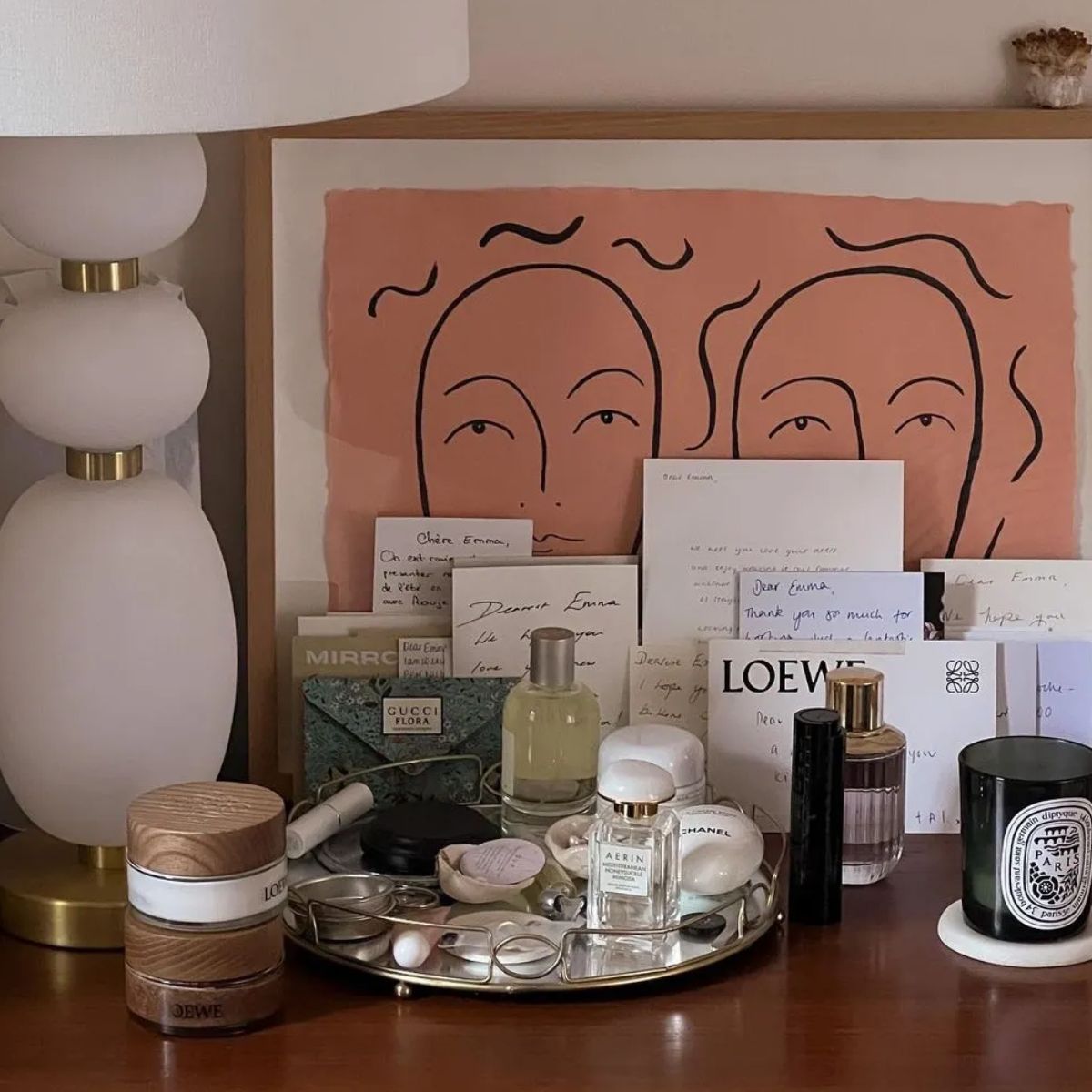 A dressing table filled with perfumes and other beauty products