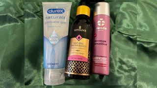 Three lubricants lined up next to each other on green velour cloth, including Durex' Naturals, Sensuva's flavored lube and Swede Original lube