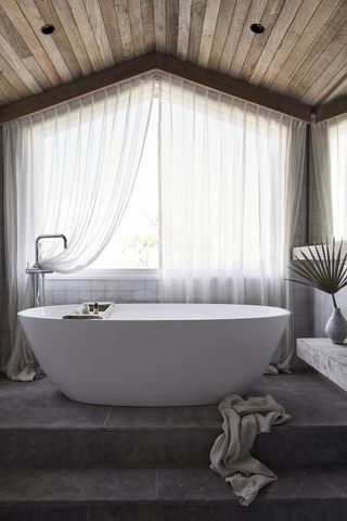 bathroom with wooden ceiling and sheer curtains