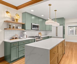 green kitchen cabinerts with neutral walls and a marble island