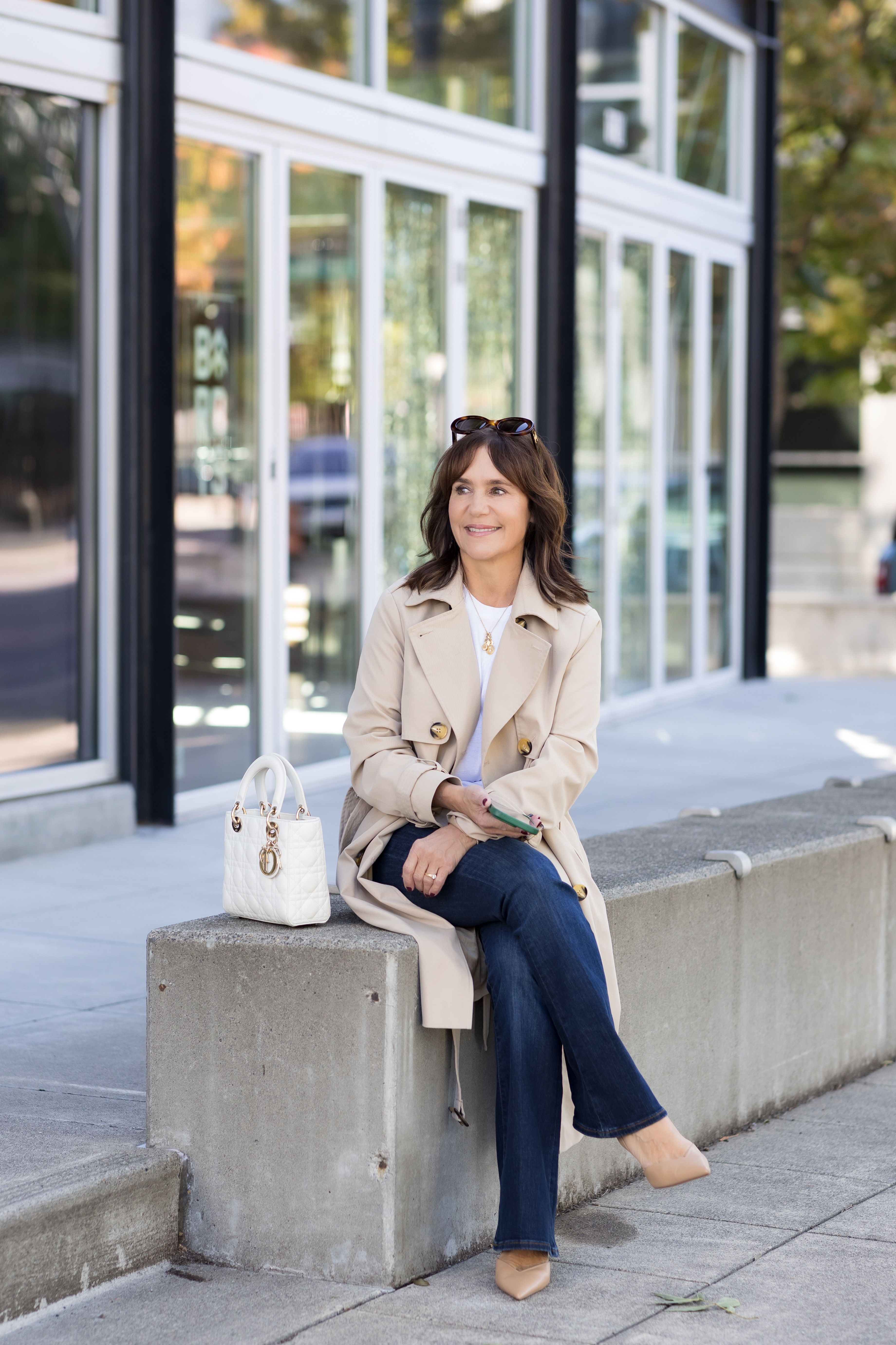Susie Wright wearing a long tan coat and dark-wash jeans.