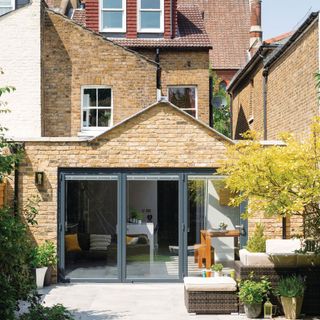 Exterior shot of the rear of a brick house with a single storey kitchen extension