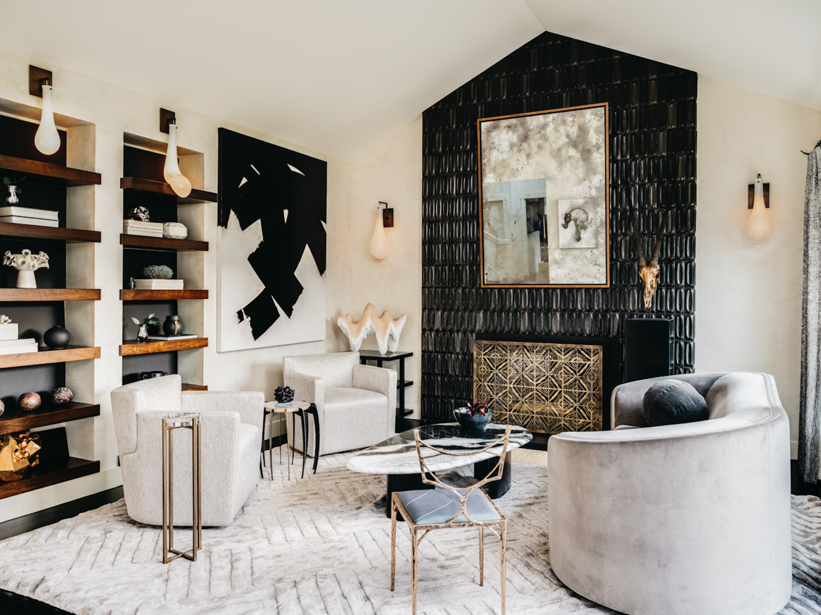 A modern living room design in black and white with a fireplace tiled floor-to-ceiling in black