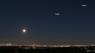 A photo of the nearly-full Harvest Moon, Jupiter and Saturn shining over New York City, taken on Sept. 19, 2021.