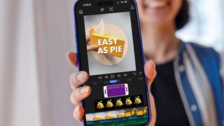 Lifestyle image of person holding iPhone running Adobe Premiere mobile with footage of an origami pie on the screen 