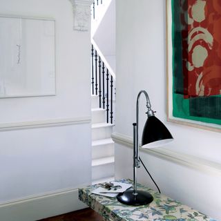 hallway with white staircase and photoframe on wall