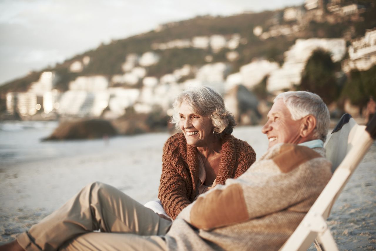 A couple relaxes on a beach. 