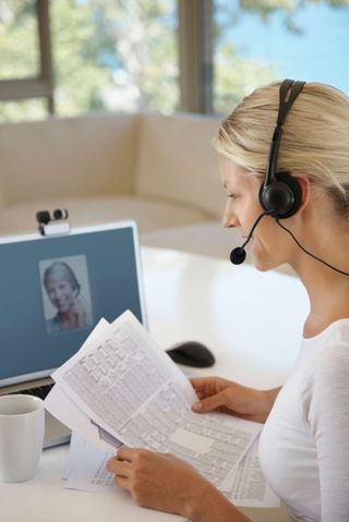 Woman with headphones and laptop computer in a video conference.