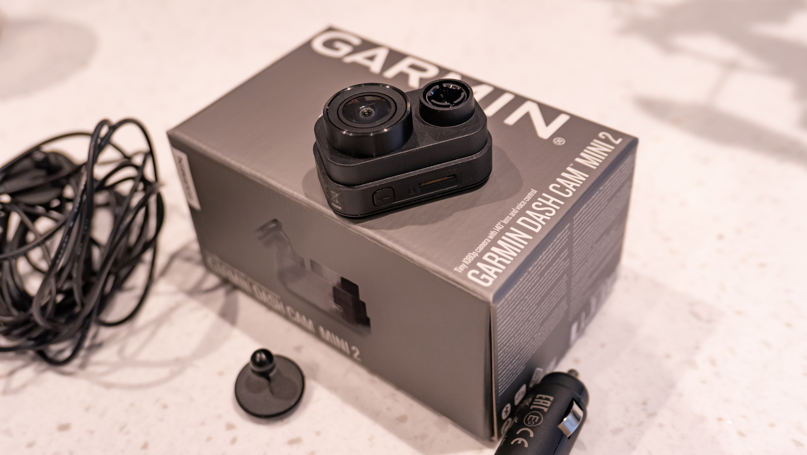 The Garmin Dash Cam Mini 2 next to its box on a table