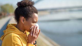 A runner stops to blow her nose