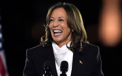 Kamala Harris speaking in Washington DC wearing a white top with a gold flag pin