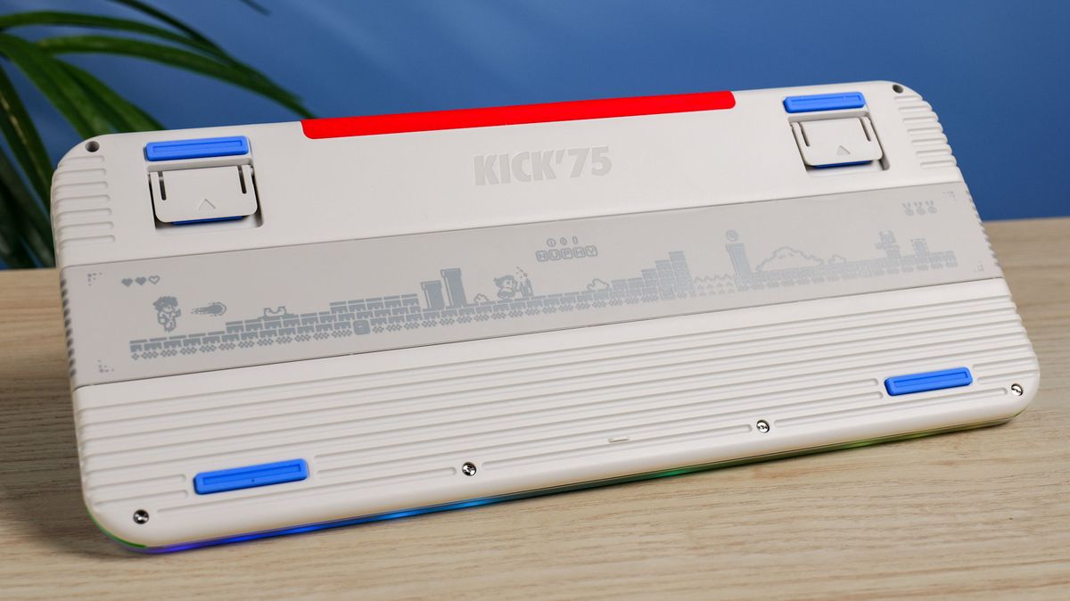 The rear of the NuPhy Kick75 on a wooden surface with a blue wall in the background