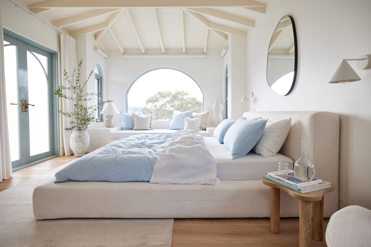 a white bedroom with light blue sheets