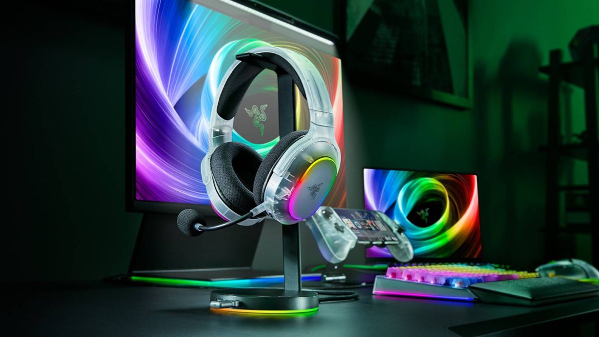 Promo image showing a translucent Razer headset sitting on a stand, with a monitor and matching accessories behind it.
