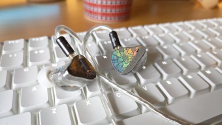Two photos of the EP321 MEMS earphones, placed on a white keyboard.