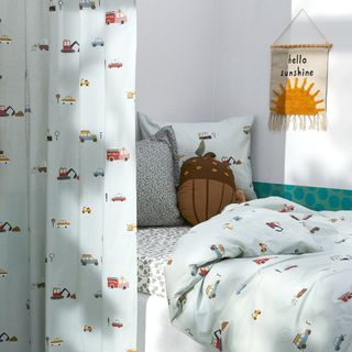 A kids room with duvet set printed with vehicles