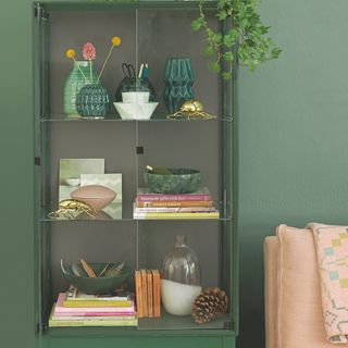 green glass display cabinet in green living room