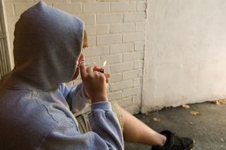 A young man smokes a drug.