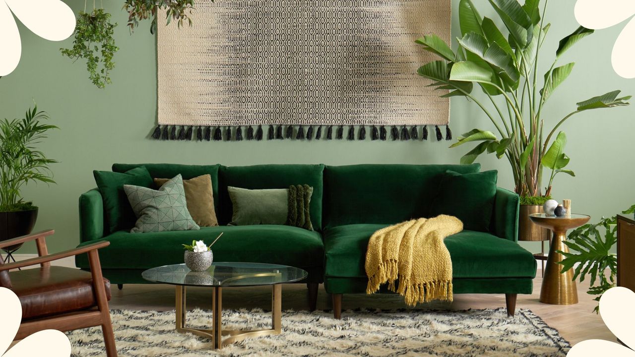 A dark green sectional with tonal green cushions in a green living room with lots of plants, styled by Joybird one of 2023&#039;s best sustainable furniture brands.