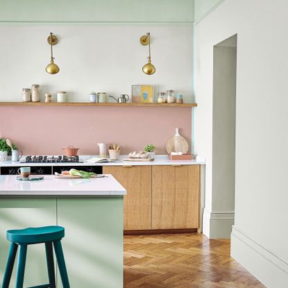 Pink kitchen walls with brass lights and open shelving