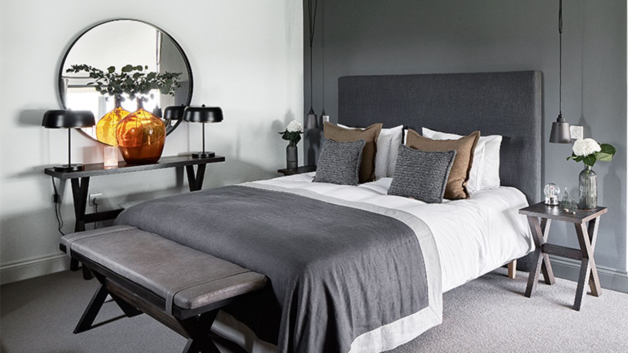 loft bedroom with grey feature wall and hotel style bed