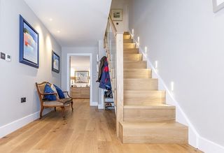 bright hallway with LED lighting and wooden staircase