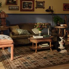 A living room with a gallery wall, a green velvet sofa and the Ruggable Calloway brown multicolour rug on the floor