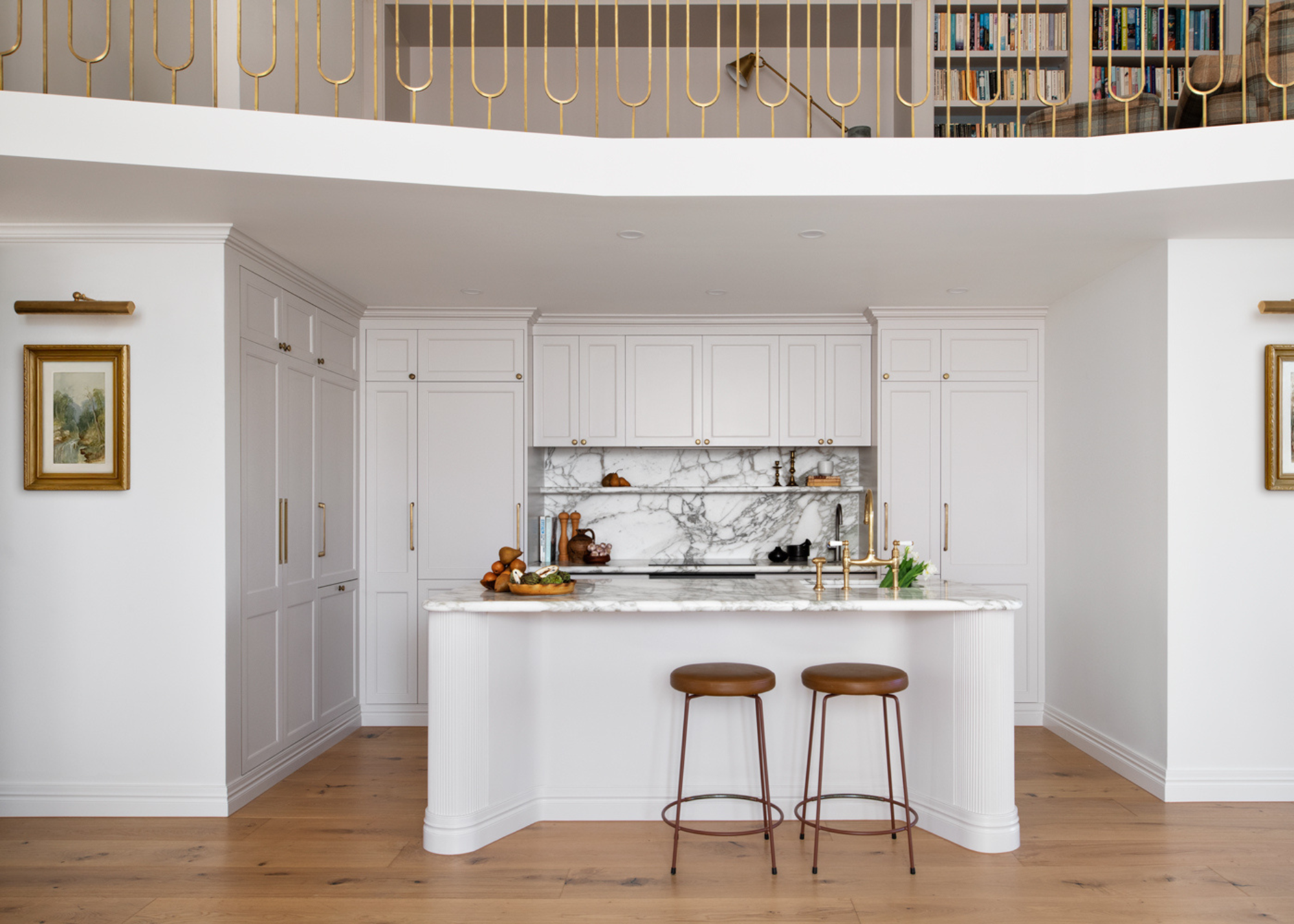 An all-white modern traditional kitchen with an island and mezzanine above