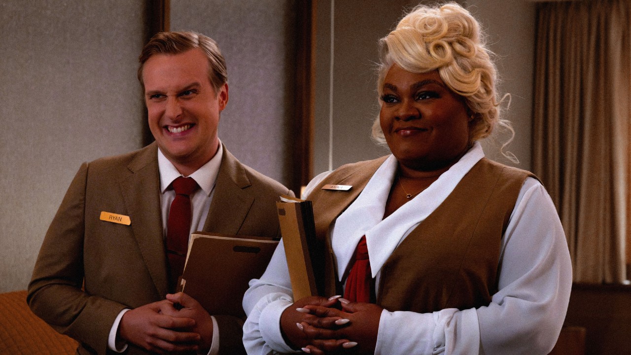 From left to right: John Early and Da'Vine Joy Randolph standing together and they're both holding files in Eternity.