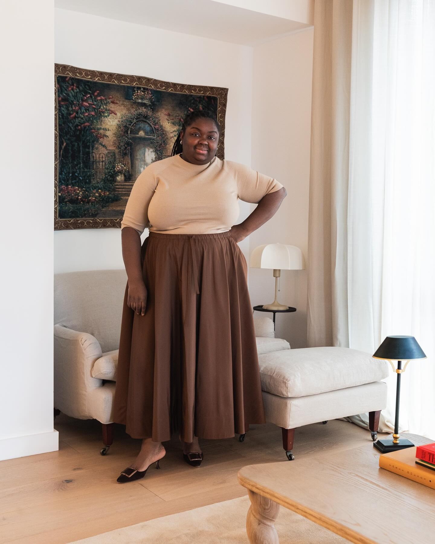 Image of Abi Marvel photographed by Shini Park in a brown maxi skirt and beige crewneck.