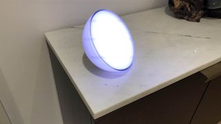 The Philips Hue Go Portable Light illuminated on a cabinet