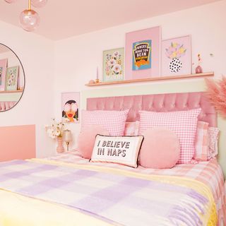 pink bedroom with upholstered bed and picture ledge