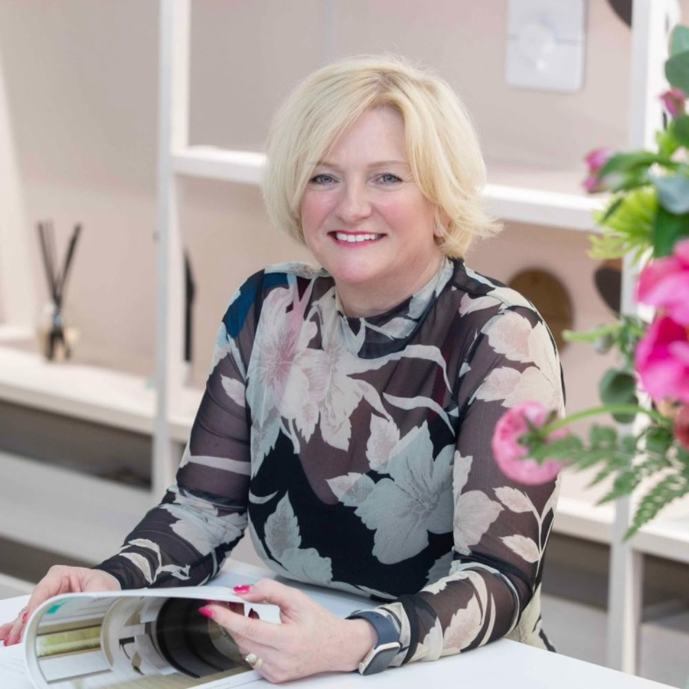 Headshot of a woman with short blonde smiling at the camera