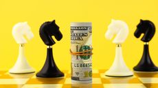 Chess pieces and a roll of money on a chess board.