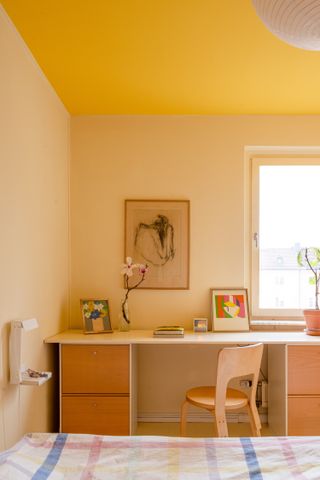 A bedroom with bright yellow ceiling and buttery-yellow walls