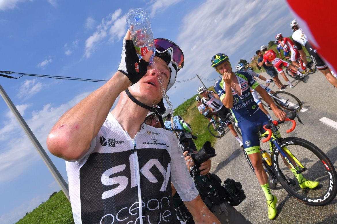Chris Froome washes out his eyes after gendarmes' pepper spray wafted over the peloton behind a protest
