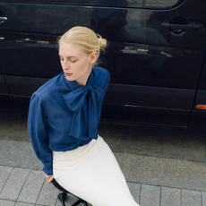 A model wearing a denim blouse and white skirt from Otrium.