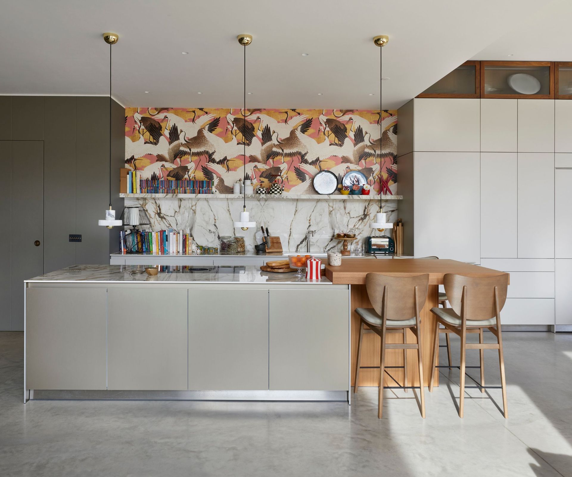 A gray and white modern kitchen decorated with a bold botanical wallpaper