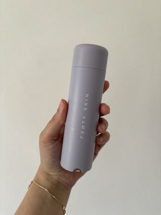 mica holding Fenty Skin Hydra Vizor Huez Tinted Moisturizer SPF30