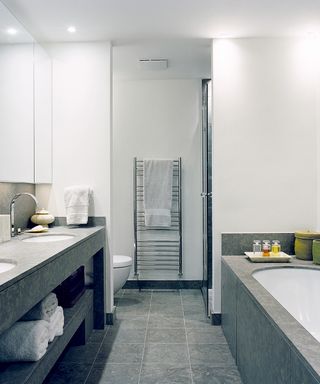 An example of bathroom lighting ideas showing a white and gray bathroom with bright lighting recessed
