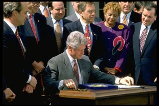 Pres. Bill Clinton signing legislation in White House Rose Garden ceremony.