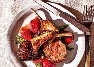 two lamb chops on a bed of roasted strawberry sauce