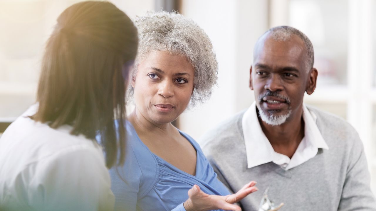 An older couple talk with a financial adviser.