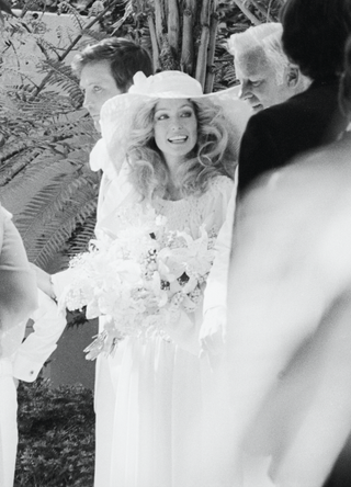 American actress Farrah Fawcett is escorted by her father James Fawcett at her wedding to actor Lee Majors at the Hotel Bel-Air, Los Angeles, California, July 28, 1973