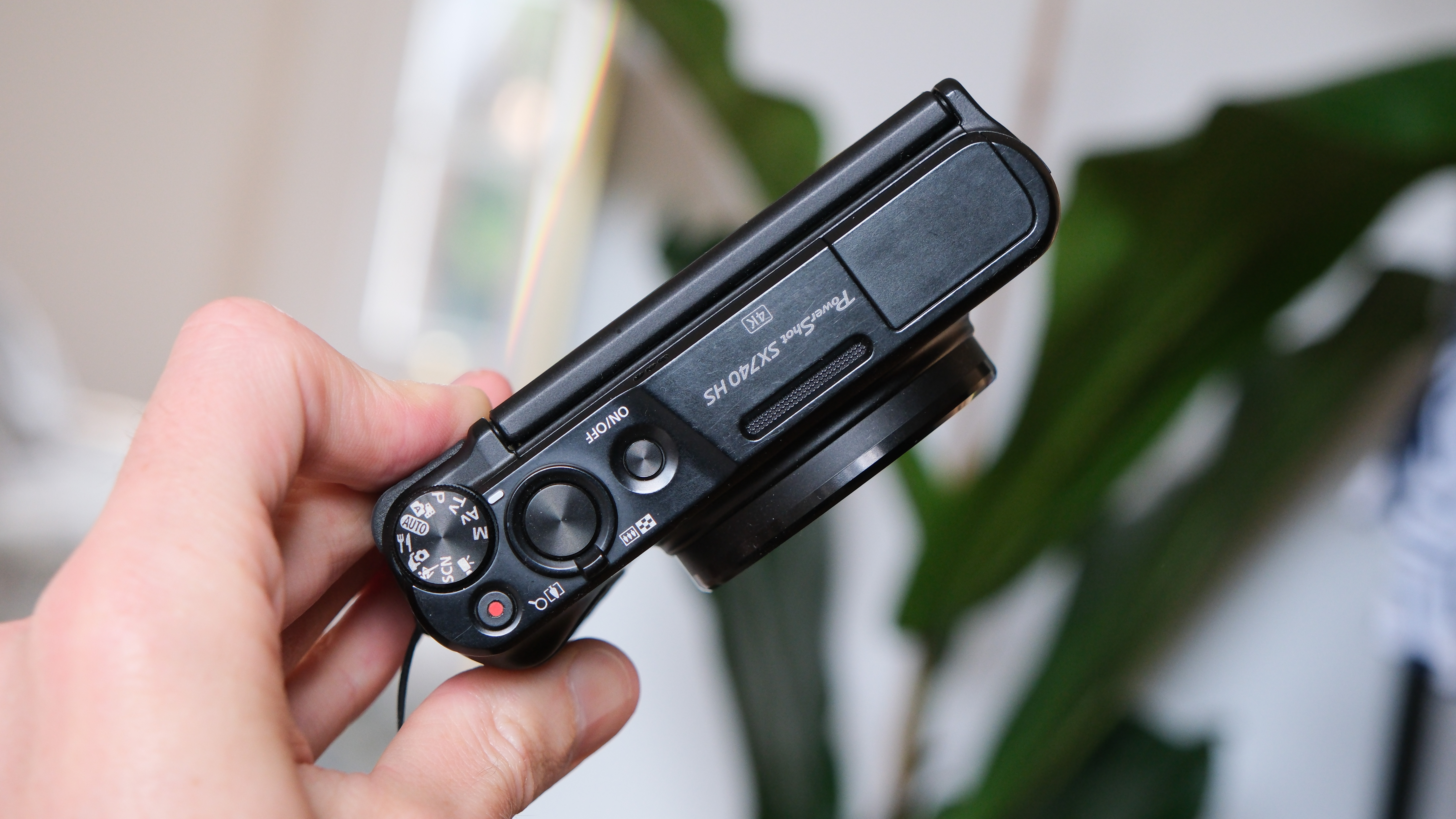 Canon PowerShot SX740 HS compact camera held in a hand