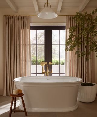 A bathroom with high ceilings and a standalone bathtub