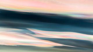 close up photograph of nacreous clouds shining pastel colors of pink, orange, yellow, blue, purple and green.