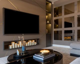Fireplace with wall mounted TV and candles, reflected in the mirror