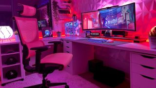 An ergonomic mesh desk chair sitting in front of an ultrawide gaming monitor, with bright pink LED lighting illuminating the room.